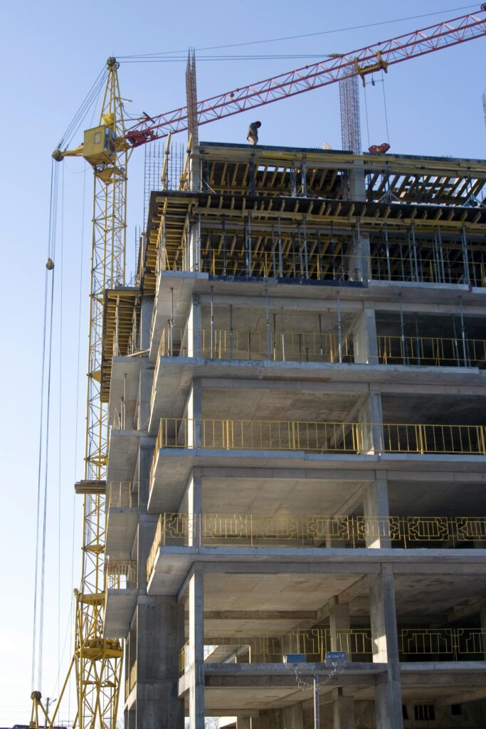 High-rise building under construction with a tower crane. Captures the modern construction process.